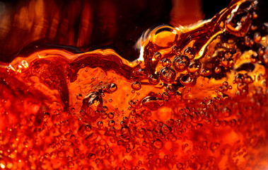 Alcoholic drink on a dark background, abstract splashing.