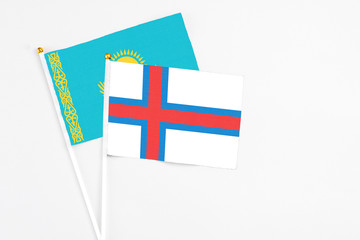 Faroe Islands and Kazakhstan stick flags on white background. High quality fabric, miniature national flag. Peaceful global concept.White floor for copy space.