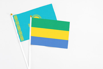 Gabon and Kazakhstan stick flags on white background. High quality fabric, miniature national flag....