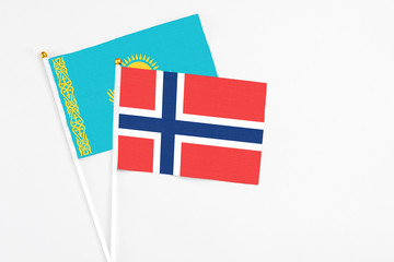 Norway and Kazakhstan stick flags on white background. High quality fabric, miniature national flag. Peaceful global concept.White floor for copy space.