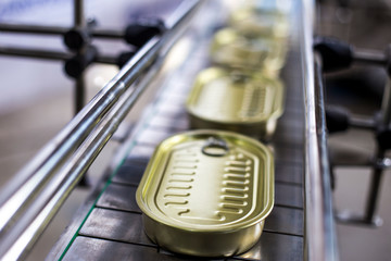 Tin can on the conveyor. Production of canned fish