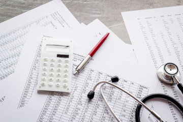 Naklejka na ściany i meble Health insurance concept. Stethoscope near financial documents and calculator on grey background