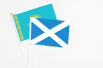 Scotland and Kazakhstan stick flags on white background. High quality fabric, miniature national flag. Peaceful global concept.White floor for copy space.