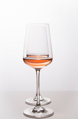 Rose wine in the glass at white background, romantic and elegant wine photo with copy space