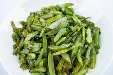 Freshly cut sea cabbage on a saucer on a white background