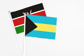 Bahamas and Kenya stick flags on white background. High quality fabric, miniature national flag. Peaceful global concept.White floor for copy space.