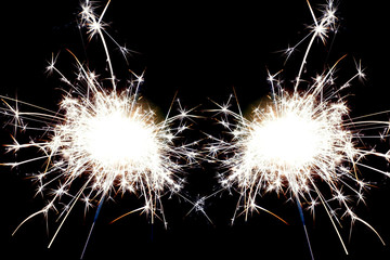 Two christmas sparklers on black background.