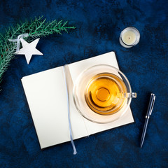 New Year's resolutions or bucket list concept, a flat lay top-down shot on a dark blue background with Christmas decorations and a cup of tea