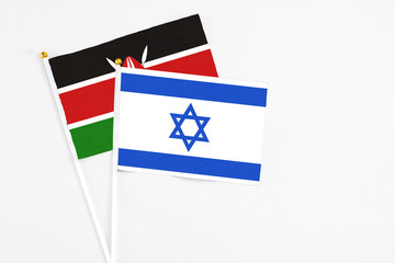 Israel and Kenya stick flags on white background. High quality fabric, miniature national flag. Peaceful global concept.White floor for copy space.
