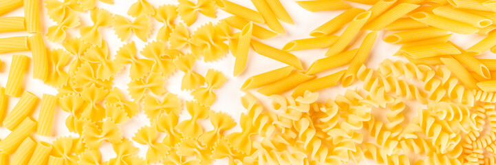 Italian pasta panorama, a flat lay texutre on a white background. Fusilli, farfalle, penne, rigatoni