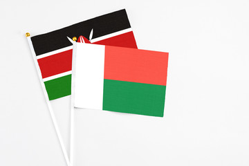 Madagascar and Kenya stick flags on white background. High quality fabric, miniature national flag. Peaceful global concept.White floor for copy space.