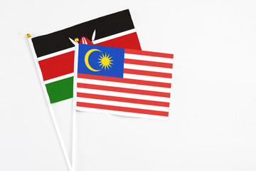 Malaysia and Kenya stick flags on white background. High quality fabric, miniature national flag. Peaceful global concept.White floor for copy space.
