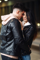 Young couple in love hug each other and have fun  in underground crossing. Couple of man and woman walking into a tunnel. Happy to be together. Love, romantic, passion, tenderness concept.