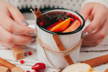 Hot muilled wine in woman's hands close up