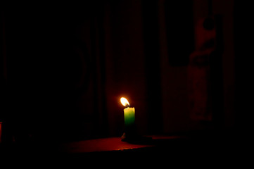 Burning candle in dark background. Closeup of candle with its flame	