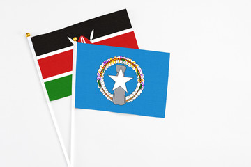 Northern Mariana Islands and Kenya stick flags on white background. High quality fabric, miniature national flag. Peaceful global concept.White floor for copy space.