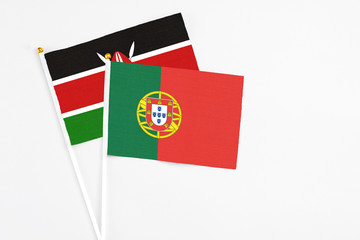 Portugal and Kenya stick flags on white background. High quality fabric, miniature national flag. Peaceful global concept.White floor for copy space.