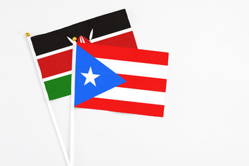 Fototapeta premium Puerto Rico and Kenya stick flags on white background. High quality fabric, miniature national flag. Peaceful global concept.White floor for copy space.
