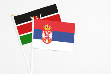 Serbia and Kenya stick flags on white background. High quality fabric, miniature national flag. Peaceful global concept.White floor for copy space.