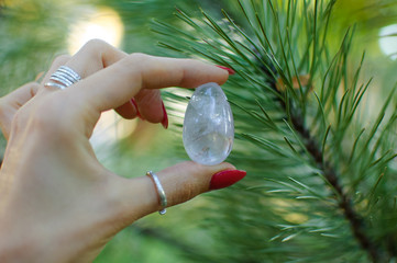 Female hand with transparent amethyst quartz yoni egg for vumfit, imbuilding or meditation. Shining...