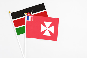 Wallis And Futuna and Kenya stick flags on white background. High quality fabric, miniature national flag. Peaceful global concept.White floor for copy space.