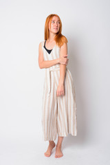 Full body shot of young beautiful redhead woman thinking