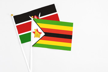 Zimbabwe and Kenya stick flags on white background. High quality fabric, miniature national flag. Peaceful global concept.White floor for copy space.