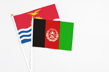 Afghanistan and Kiribati stick flags on white background. High quality fabric, miniature national flag. Peaceful global concept.White floor for copy space.