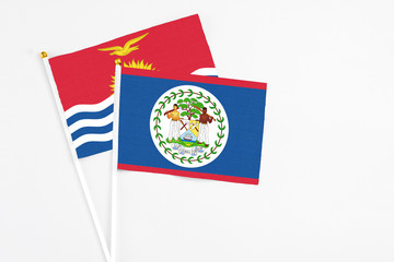 Belize and Kiribati stick flags on white background. High quality fabric, miniature national flag. Peaceful global concept.White floor for copy space.