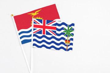 Fototapeta premium British Indian Ocean Territory and Kiribati stick flags on white background. High quality fabric, miniature national flag. Peaceful global concept.White floor for copy space.