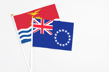 Cook Islands and Kiribati stick flags on white background. High quality fabric, miniature national flag. Peaceful global concept.White floor for copy space.