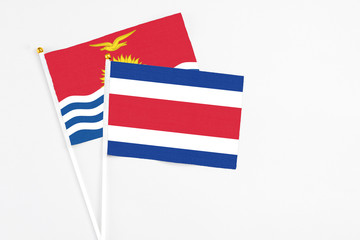 Costa Rica and Kiribati stick flags on white background. High quality fabric, miniature national flag. Peaceful global concept.White floor for copy space.