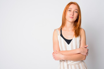 Portrait of young beautiful redhead woman with arms crossed