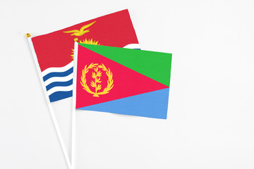 Eritrea and Kiribati stick flags on white background. High quality fabric, miniature national flag. Peaceful global concept.White floor for copy space.