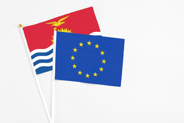 European Union and Kiribati stick flags on white background. High quality fabric, miniature national flag. Peaceful global concept.White floor for copy space.