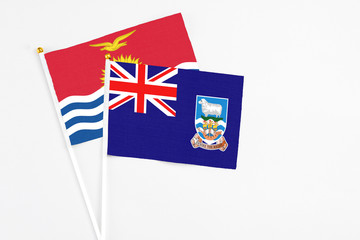 Falkland Islands and Kiribati stick flags on white background. High quality fabric, miniature national flag. Peaceful global concept.White floor for copy space.