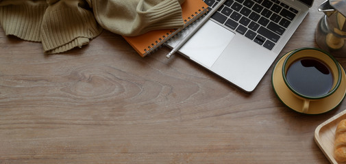 Top view of comfortable workplace with laptop computer and office supplies with breakfast on wooden...
