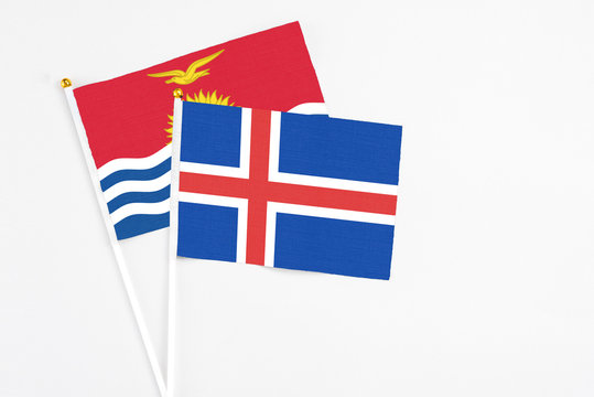 Iceland and Kiribati stick flags on white background. High quality fabric, miniature national flag. Peaceful global concept.White floor for copy space.