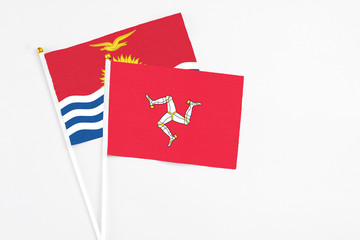 Isle Of Man and Kiribati stick flags on white background. High quality fabric, miniature national flag. Peaceful global concept.White floor for copy space.