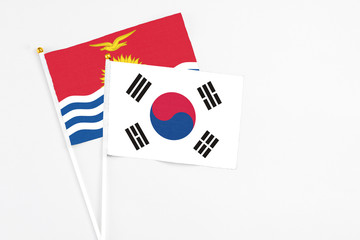 South Korea and Kiribati stick flags on white background. High quality fabric, miniature national flag. Peaceful global concept.White floor for copy space.