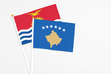 Kosovo and Kiribati stick flags on white background. High quality fabric, miniature national flag. Peaceful global concept.White floor for copy space.