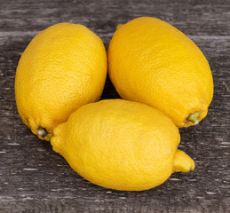 fresh lemons on wooden background close up
