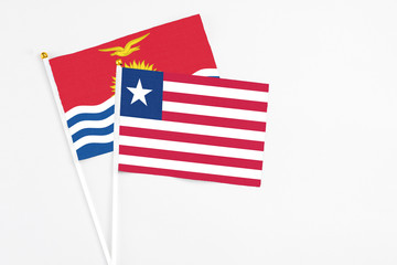 Liberia and Kiribati stick flags on white background. High quality fabric, miniature national flag. Peaceful global concept.White floor for copy space.