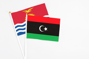 Libya and Kiribati stick flags on white background. High quality fabric, miniature national flag. Peaceful global concept.White floor for copy space.