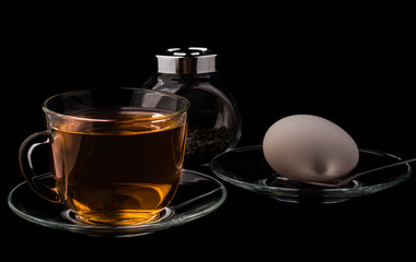 diet early Breakfast, a Cup of tea and an egg on a black background