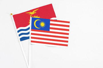Malaysia and Kiribati stick flags on white background. High quality fabric, miniature national flag. Peaceful global concept.White floor for copy space.