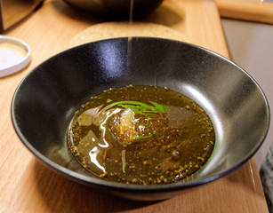 preparing honey syrup in black dish closeup