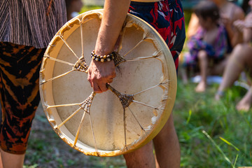 Sacred drums during spiritual singing. A close-up view and side view of shirtless man's hand...