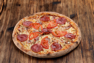 Classic salami pizza with melted cheese on wooden rustic table