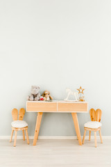 Chairs and table near wall in children's room. Interior scandinavian style.